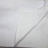 A close-up of a white textured fabric, likely a plush fleece or terry cloth, folded over to show its soft, nubby surface.